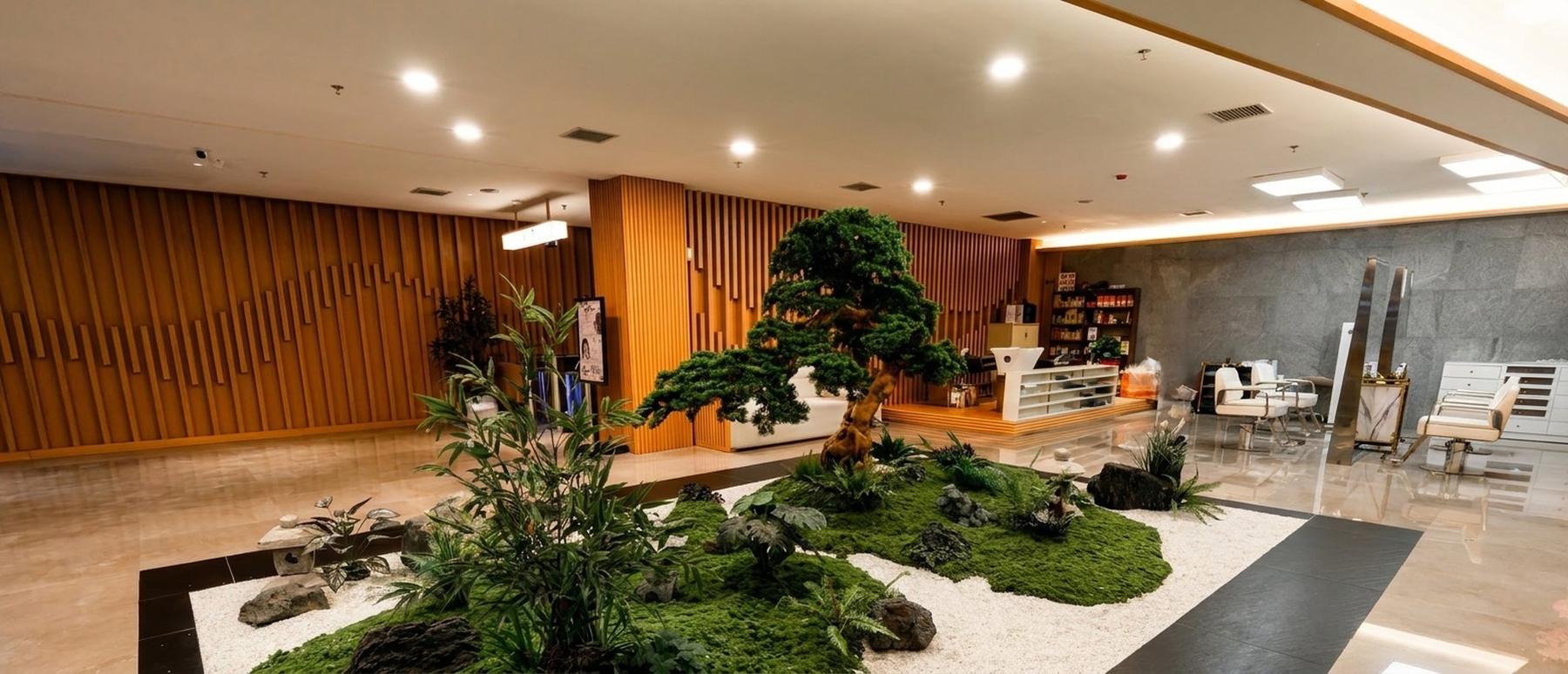 A modern spa lobby with an indoor garden, bonsai tree and moss mounds