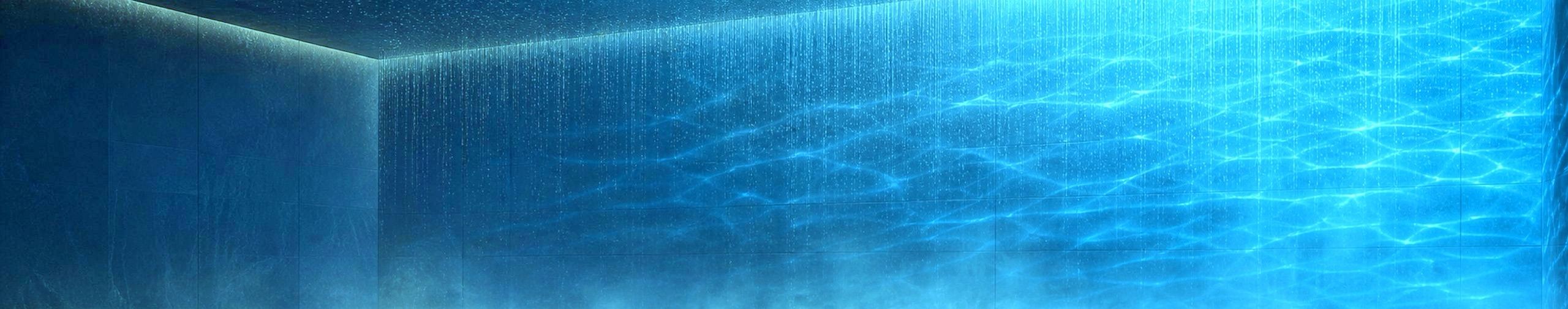 A blue illuminated water curtain with shimmering reflections